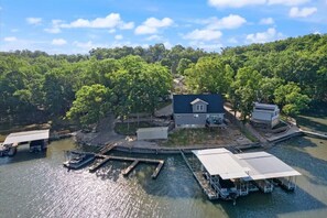 A lakeside property with a house, dock, and boat. - Kamp's Place at Mallard Cove (Linn Creek)