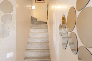 Eine Treppe mit einer hellen Wand und runden Spiegeln.
