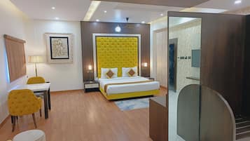 Una habitación de hotel con una cama, un escritorio, una silla, una lámpara y un espejo.
