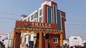 A hotel named '7 Hills' with a prominent entrance and a sign indicating it is a unit of Shrivirindavan Entrepreneur Pvt. Ltd.