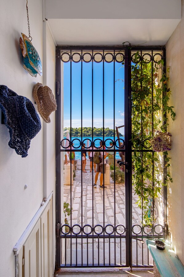A gate with a view of a body of water and people in the distance.