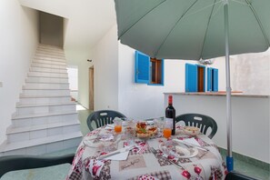 A dining area with a table set for two, a bottle of wine, and a plate of food. - 3678 A Casa di Vito by Barbarhouse (Salve)
