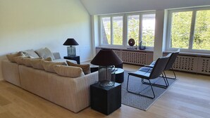 Una sala moderna con un sofá, dos mesitas auxiliares y una silla.
