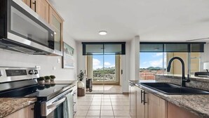 A modern kitchen with a large island, stainless steel appliances, and a view to the outside. - Victoria Marine’s View | Modern 3BR in Fajardo (Fajardo)