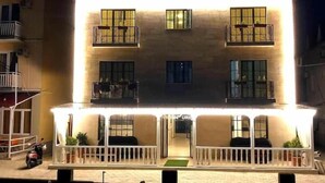 Un immeuble à deux étages doté de balcons, d’une entrée couverte et de plantes en pot.