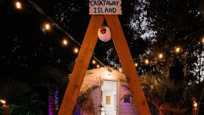 Un arco de madera con un letrero que dice "CASHTAWAY ISLAND" dando acceso a un pequeño edificio.