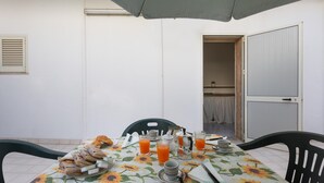 A dining table with a sunflower tablecloth, a coffee pot, and several glasses of orange juice. - 3679 Mono Le Vele (Salve)
