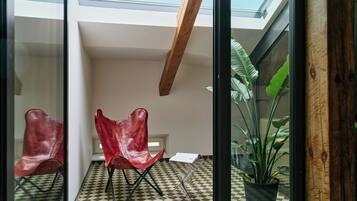 A modern room with a checkered floor, a skylight, and a potted plant.