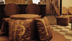 Un coin salon confortable avec des poufs ronds et une grande œuvre d’art encadrée au mur.