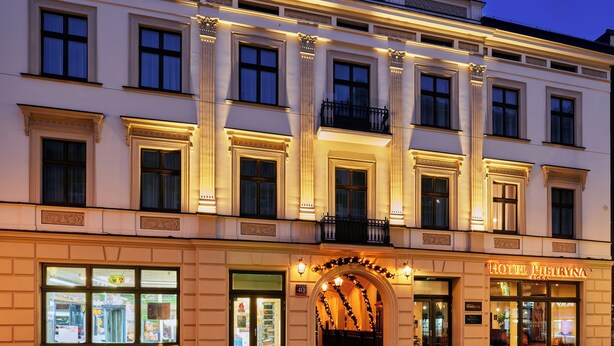 Um hotel com fachada clássica, janelas grandes e entrada ornamentada.