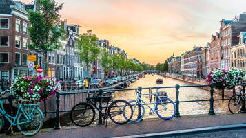 A canal-side view with bicycles, a bridge, and traditional buildings.