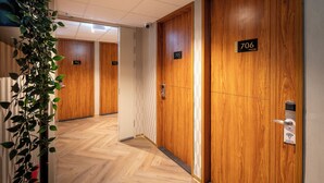 Un pasillo con puertas de madera, numeradas 706, 705 y 703.
