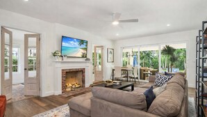Un salón amplio con chimenea, un televisor de pantalla plana grande y una zona de estar cómoda.