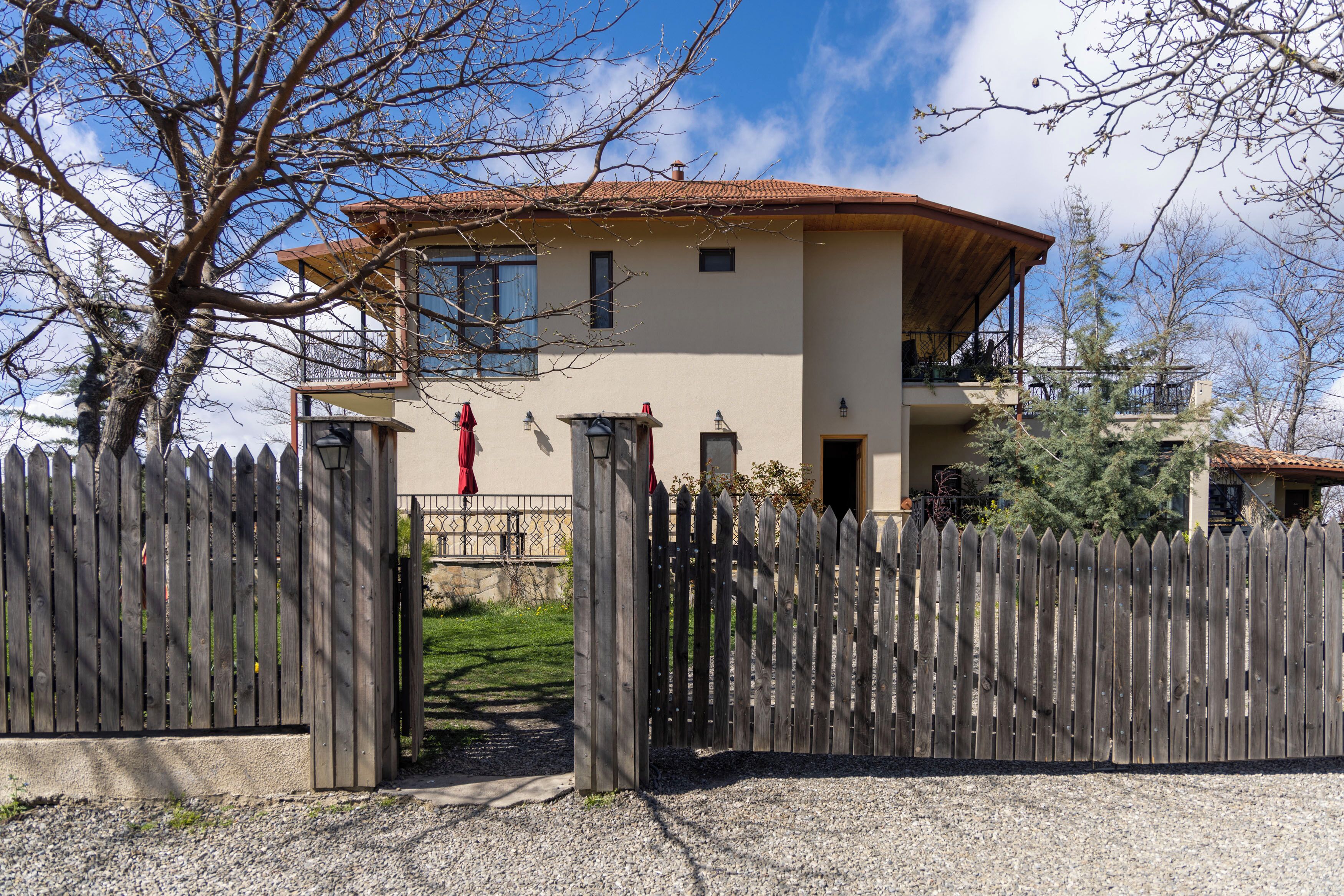 A two-story house with a wooden fence in front.