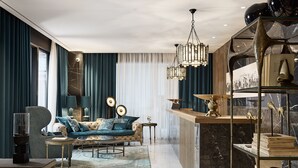 A modern living room with a sofa, a coffee table, and a chandelier. - Athenarum Portus Life & Style Hotel (Piraeus)