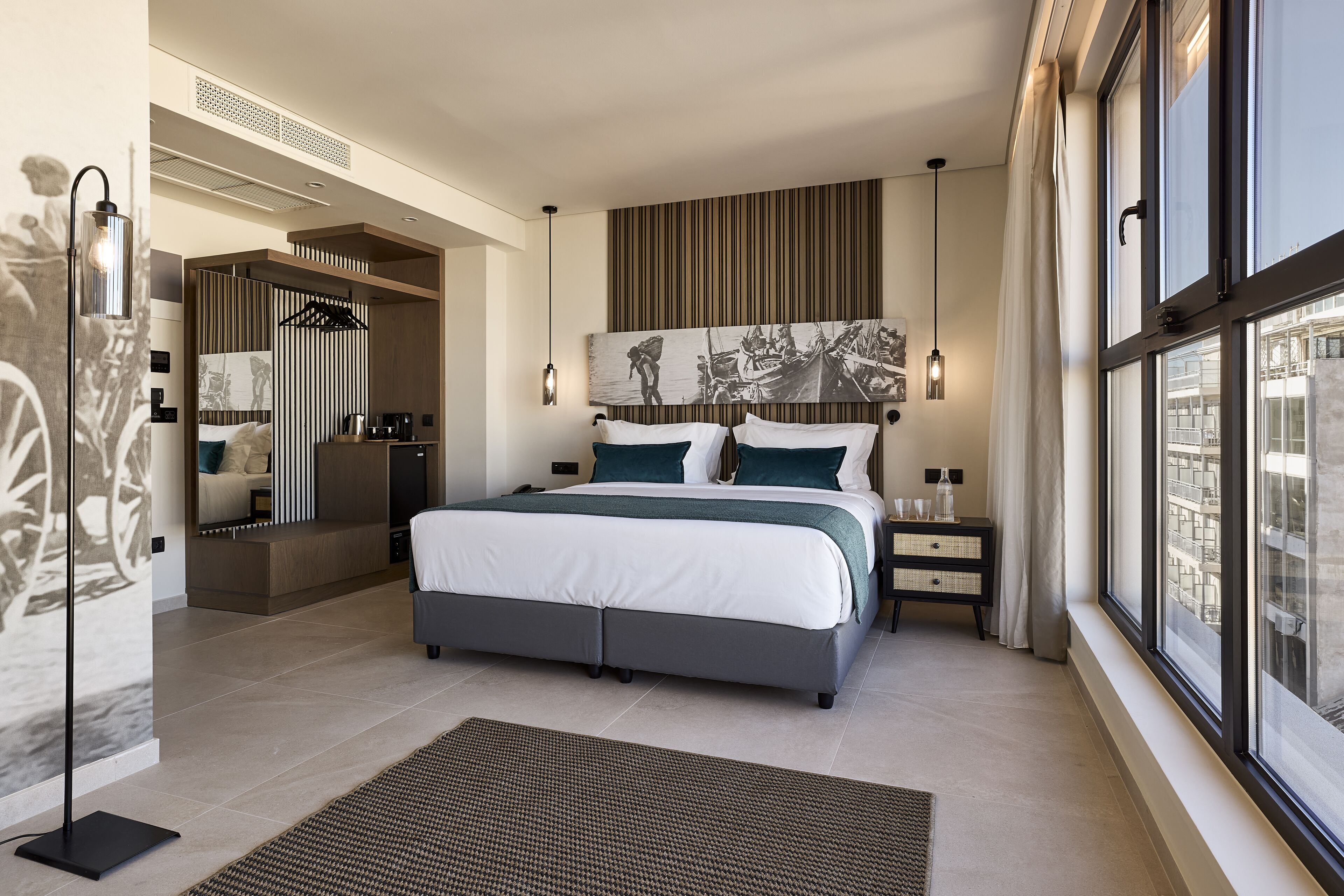 Un dormitorio moderno con una cama grande, vistas de la ciudad a través de amplias ventanas y un diseño contemporáneo.