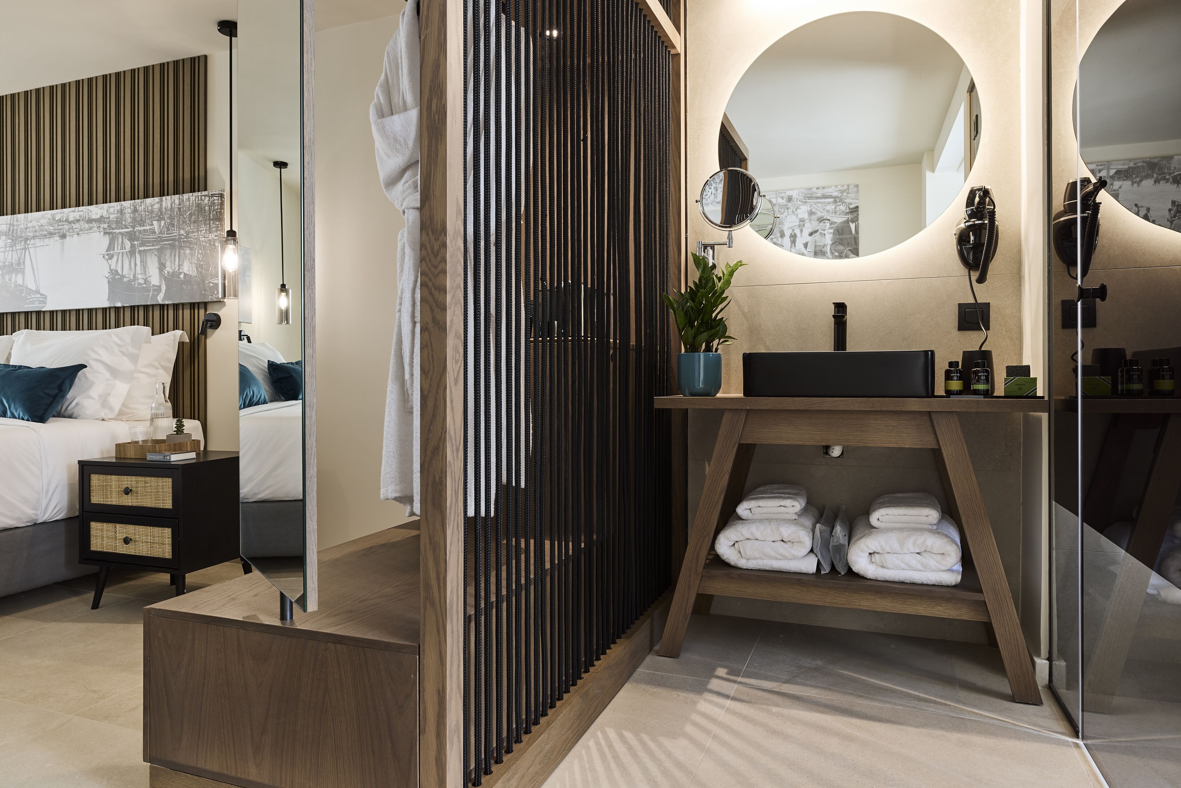 Un dormitorio moderno con cama, mesita de noche y un espejo grande.