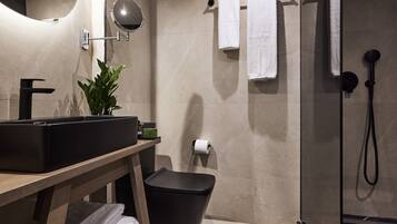 Un baño moderno con un lavamanos grande, un espejo y un perchero para toallas.