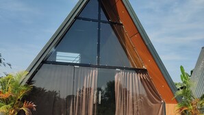 Un edificio moderno de forma triangular con un amplio frente de vidrio y detalles de madera.