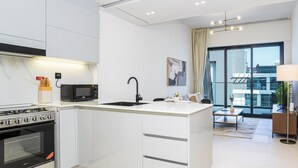 Une cuisine moderne équipée d’une cuisinière, d’un four à micro-ondes et d’un évier intégrés.