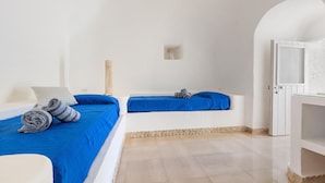 A room with two beds, each with blue bedding, a small table, and a white cabinet. - 3677 Trullo Foresta Forte by Barbarhouse (Castrignano del Capo)