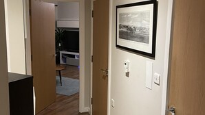 A hallway with wooden flooring, white walls, and a framed picture on the wall. - Charming 2-bed Apartment in Bow, London (London)