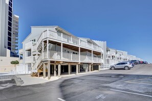 A beachfront hotel with a balcony, parking area, and a clear sky. - Perdido Dunes 29 by Liquid Life (Orange Beach)