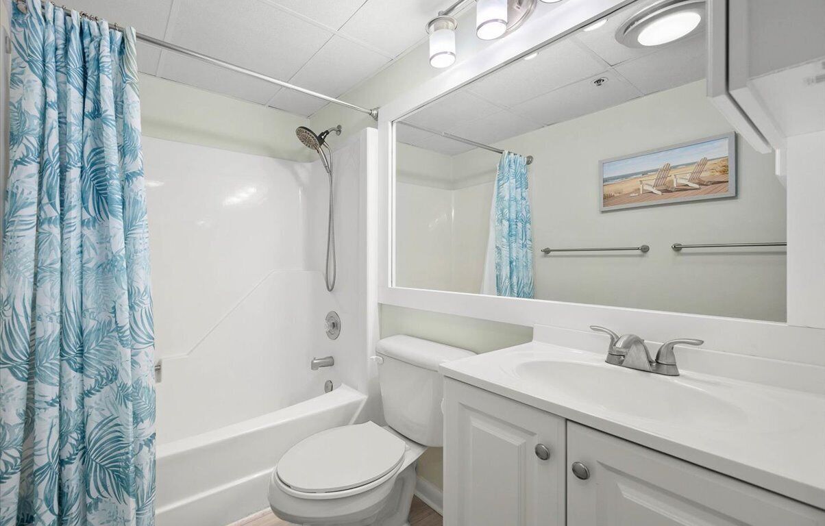 Une salle de bain avec douche, toilettes et lavabo.