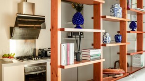 Una cocina con estantes de madera, una estufa y una campana extractora.