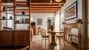 Un comedor acogedor con una mesa y sillas de madera, una estantería y una chimenea.
