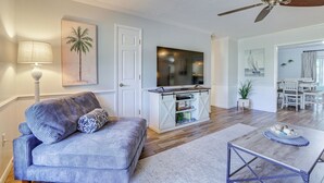 A living room with a sofa, a coffee table, a TV, and a ceiling fan. - Pet-friendly Home w/ Heated Pool in Bradenton (Bradenton)