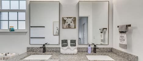 A bathroom with two sinks, a mirror, and a vanity.