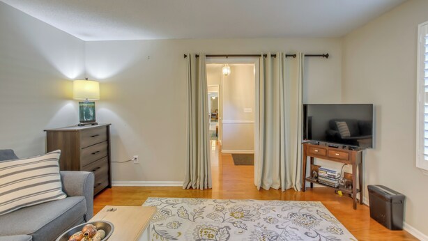 A bedroom with a sofa, a TV, a bedside table, and a lamp. - Near the Sand! Myrtle Beach Home w/ Saltwater Pool (Myrtle Beach)