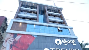 Un edificio con un letrero grande que dice "TRENDS" y una vista parcial de un mural en la pared.