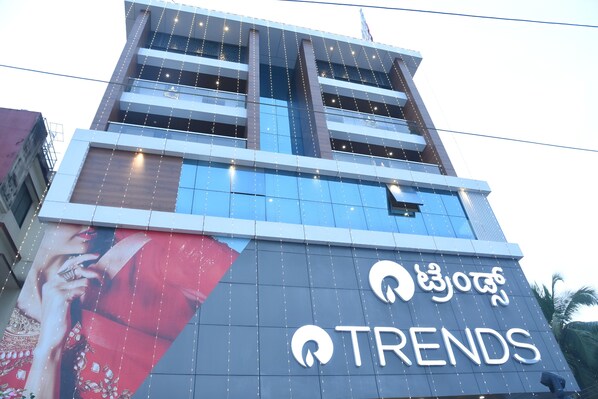 A building with a large sign reading "TRENDS" and a partial view of a mural on the side. - Aurelia Comforts (Mangaluru)