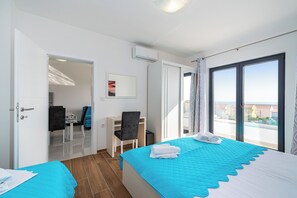 Habitación de hotel con una cama, un escritorio, una silla y vistas a la ciudad.