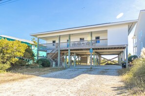 A two-story house with a covered porch and a staircase leading to the upper level.