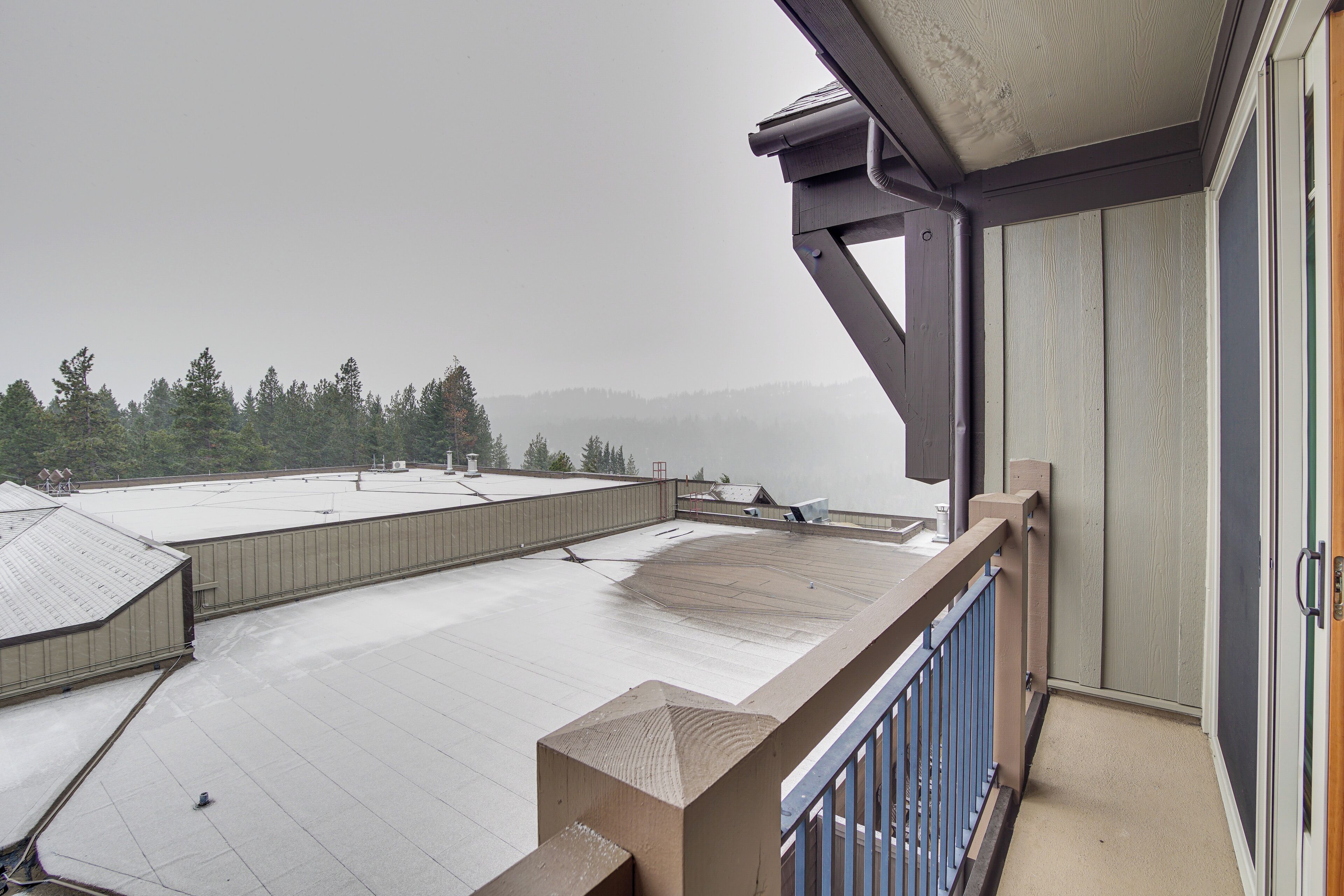 Terraço no telhado com vista para uma área arborizada.