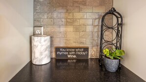 A reception area with a marble pillar, a potted plant, a sign with a rhyme, and a brick wall. - Devon Court 2 Bedroom Home by RedAwning (Hood River)