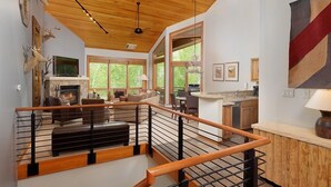 A spacious living area with a fireplace, a kitchen, and a dining area. - Contemporary Townhome With Ski-in/ski-out Access by The Woodrun V Townhouses by RedAwning (Snowmass Village)