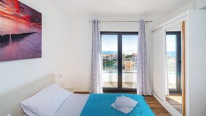 A hotel room with a bed, a view of the city, and a balcony with curtains. - Deluxe Villa Laura 6a (Novalja)