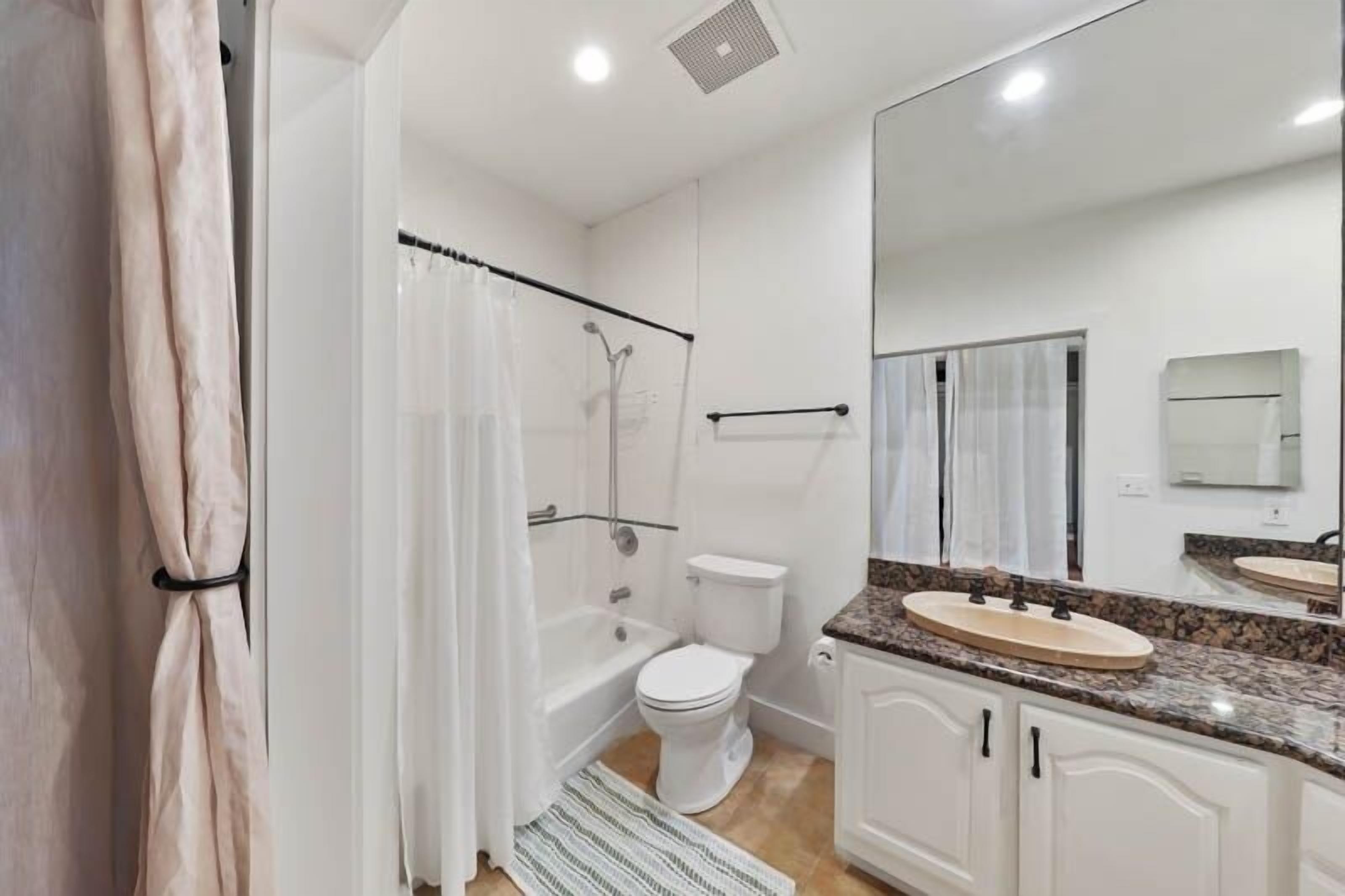 A bathroom with a bathtub, toilet, and sink.