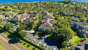 Vista aérea de una zona residencial con casas, estacionamientos y una carretera.