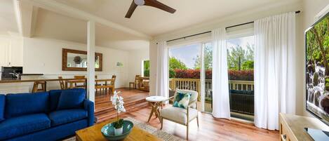 A spacious living area with a blue sofa, wooden coffee table, and a ceiling fan.
