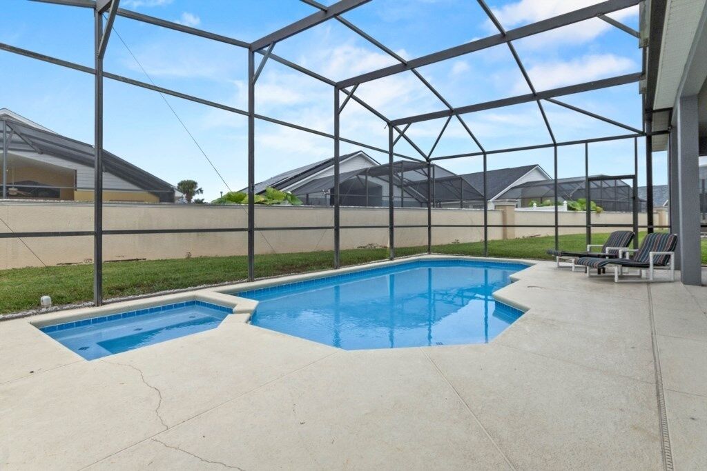 A covered outdoor swimming pool with a clear view of the surrounding neighborhood.