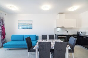 Una cocina moderna con armarios blancos, un microondas y un fregadero.