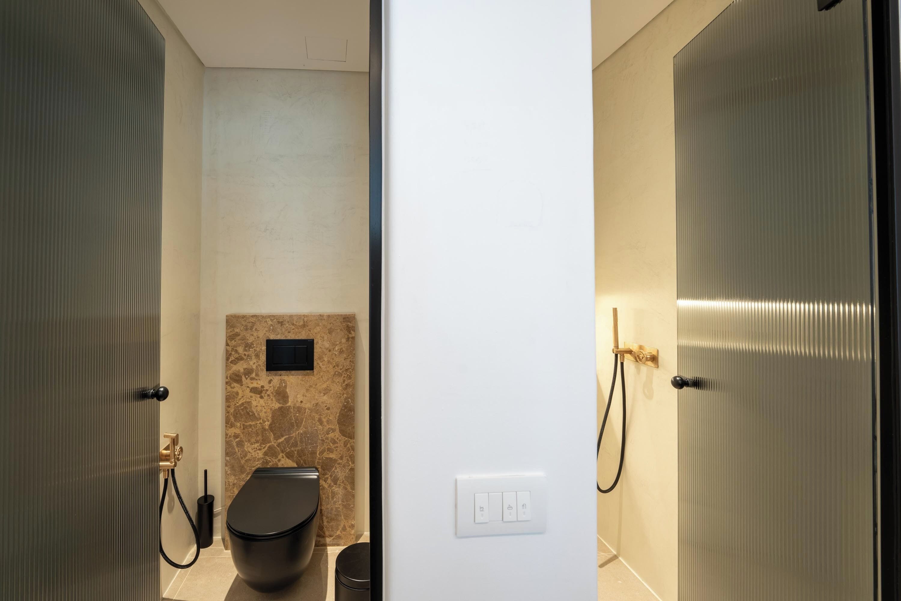 Un baño moderno con inodoro, ducha y lavamanos.