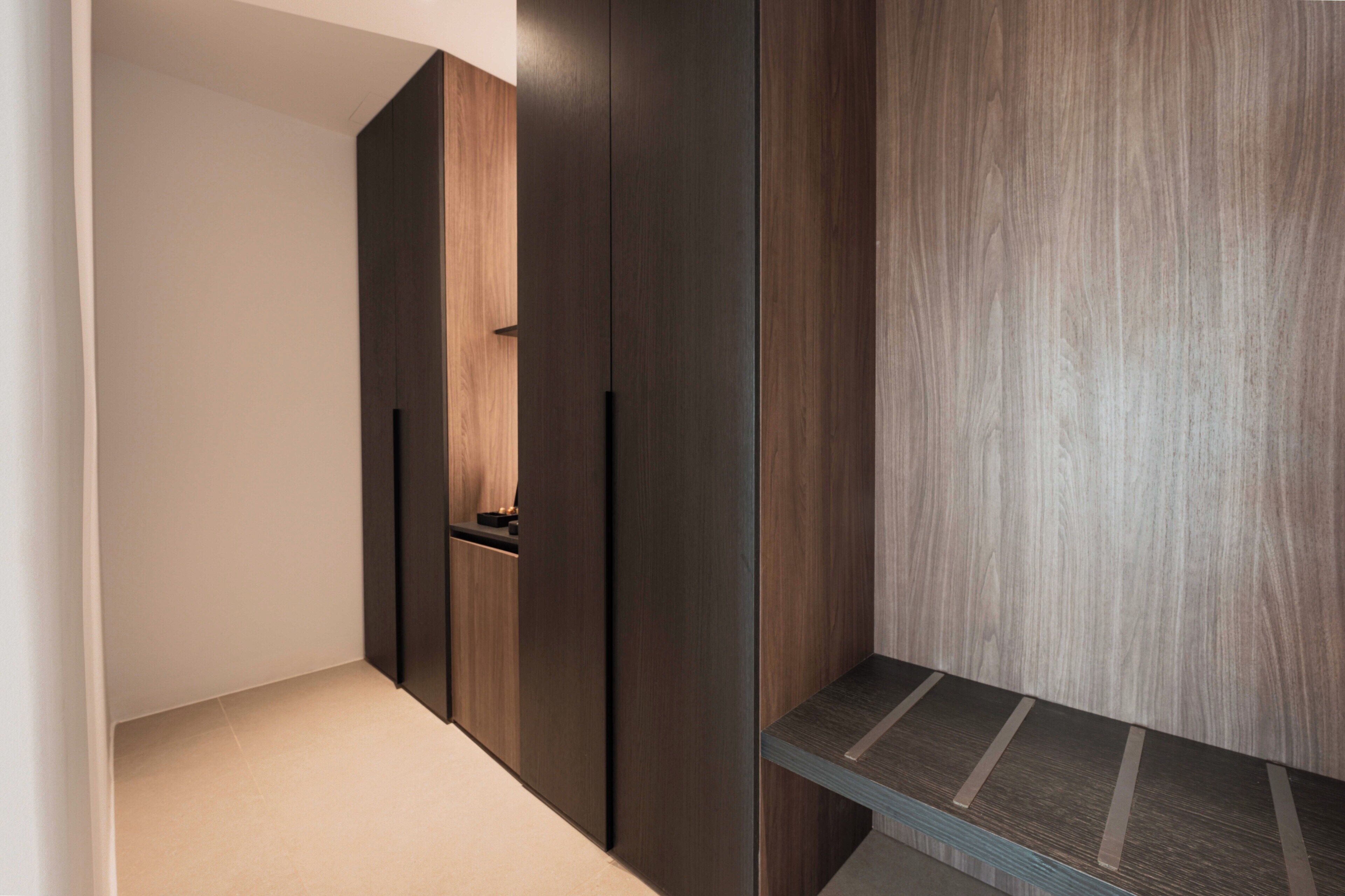 A modern interior with dark wood paneling, a built-in bench, and a minimalist design.
