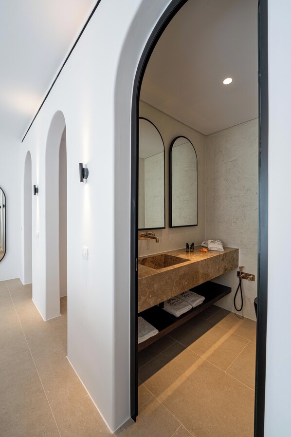A modern bathroom with a large sink, two mirrors, and a towel rack. - Muse of Mykonos (Mykonos)