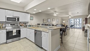 Una cocina moderna con armarios blancos, electrodomésticos de acero inoxidable y una isla grande.